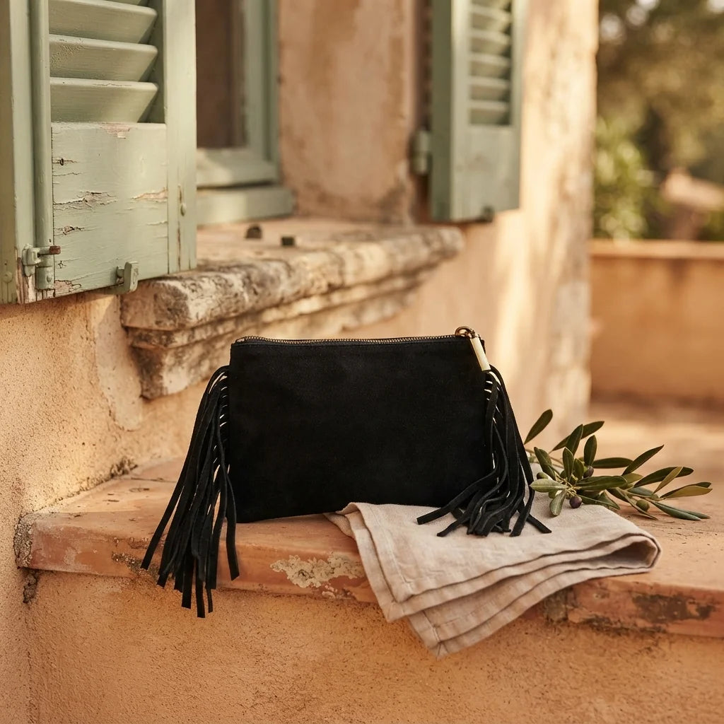 Black small suede fringe bag styled in a warm Mediterranean setting