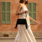 Woman wearing Black small suede fringe bag with swaying fringe