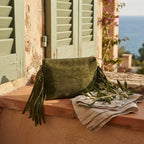 Khaki small suede fringe bag styled in a warm Mediterranean setting