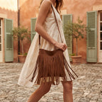 Woman wearing Brown small tan fringe bag with swaying fringe