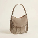 Taupe suede fringe clutch bag, three-quarter angle showing side depth