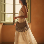 Woman wearing Taupe suede fringe clutch bag with swaying fringe