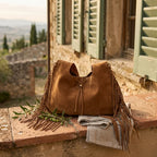 Brown suede leather fringe bag styled in a warm Mediterranean setting