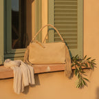 Tan tan fringe clutch bag styled in a warm Mediterranean setting