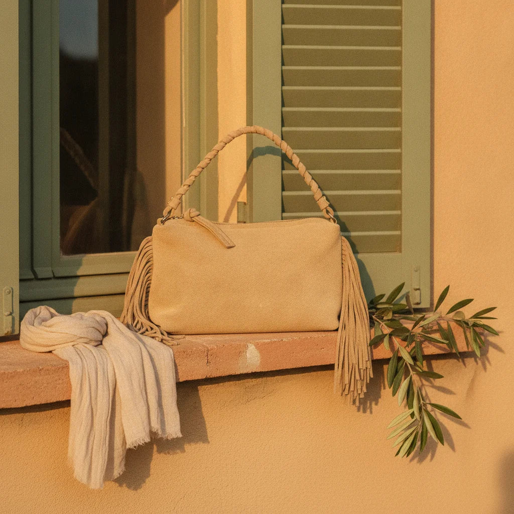 Tan tan fringe clutch bag styled in a warm Mediterranean setting