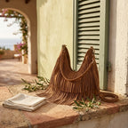 Brown tan fringe hobo bag styled in a warm Mediterranean setting