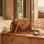 Light Brown tan suede fringe bag styled in a warm Mediterranean setting