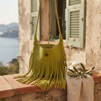 Green tassel fringe hobo bag styled in a warm Mediterranean setting