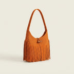 Orange tassel fringe hobo bag, three-quarter angle showing side depth