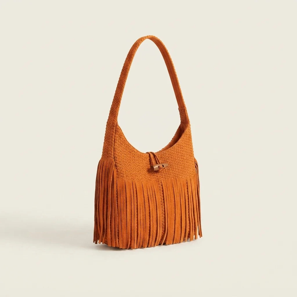 Orange tassel fringe hobo bag, three-quarter angle showing side depth