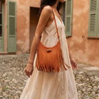 Woman wearing Orange tassel fringe hobo bag with swaying fringe