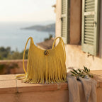 Yellow tassel fringe hobo bag styled in a warm Mediterranean setting