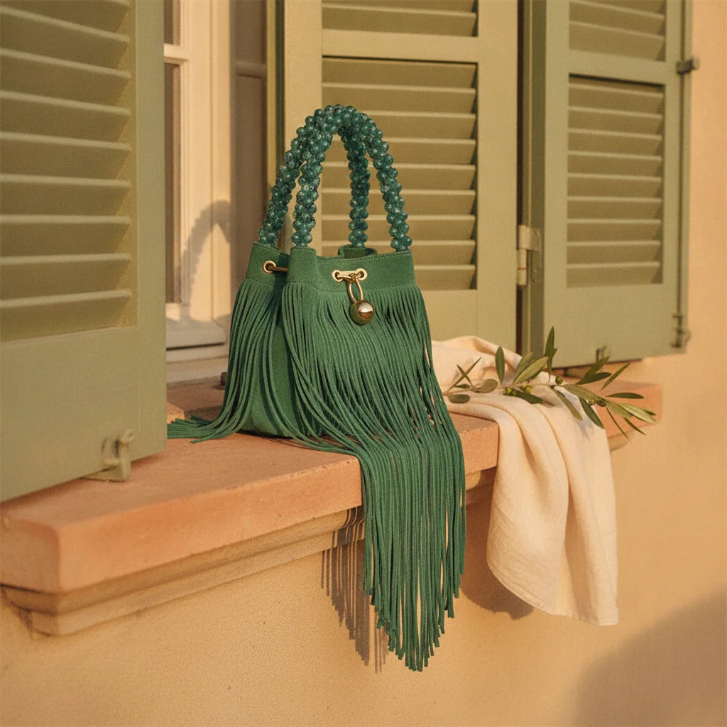 Green turquoise fringe bag styled in a warm Mediterranean setting