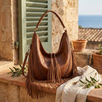 Brown vegan fringe hobo bag styled in a warm Mediterranean setting