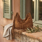Brown vintage boho fringe bag styled in a warm Mediterranean setting