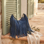 Blue vintage fringe hobo bag styled in a warm Mediterranean setting