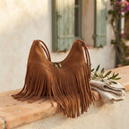 Brown vintage suede fringe bag styled in a warm Mediterranean setting