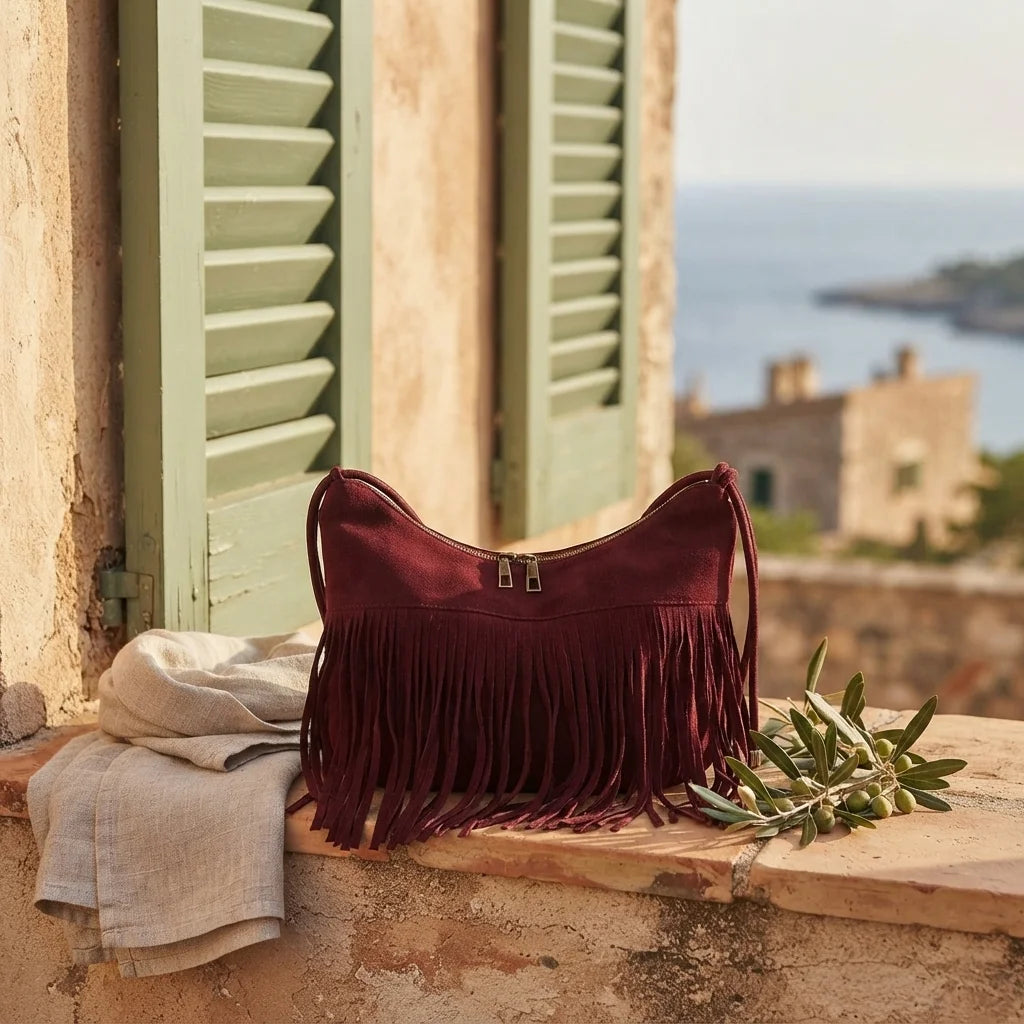 Red vintage suede fringe bag styled in a warm Mediterranean setting