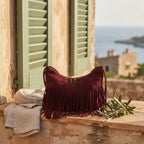 Red vintage suede fringe bag styled in a warm Mediterranean setting