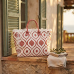 Pink & White white fringe beach bag styled in a warm Mediterranean setting