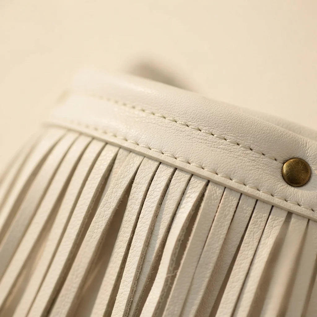 Close-up of fringe stitching and texture on White white fringe bucket bag