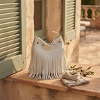 White white fringe bucket bag styled in a warm Mediterranean setting