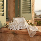 White white fringe clutch bag styled in a warm Mediterranean setting