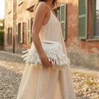 Woman wearing White white fringe clutch bag with swaying fringe