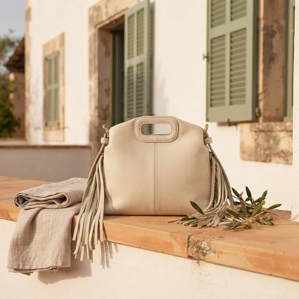Cream white fringe shoulder bag styled in a warm Mediterranean setting