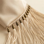 Close-up of fringe stitching and texture on Beige wristlet fringe bag